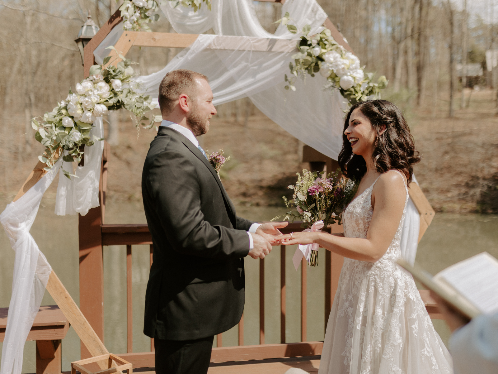 Bride and groom stand before a decorated wedding archway